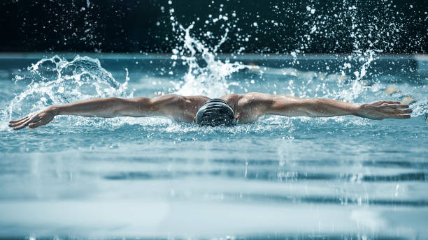 nadador dinámico y ajuste en la tapa de respiración a realizar el movimiento de la mariposa - butterfly swimmer fotografías e imágenes de stock