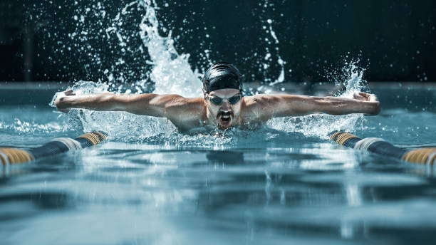 istock dynamic and fit swimmer in cap breathing performing the butterfly stroke 1032039256