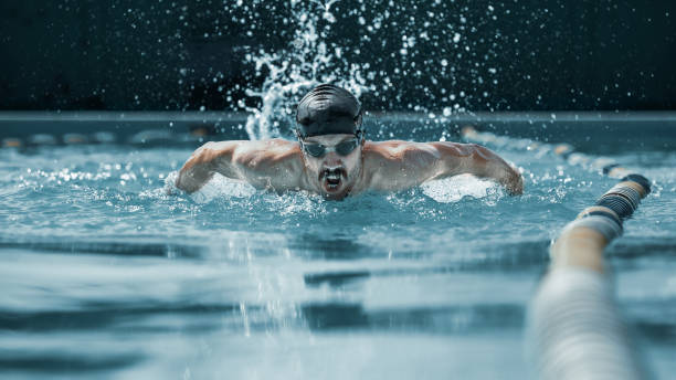 istock dynamic and fit swimmer in cap breathing performing the butterfly stroke 1032039272