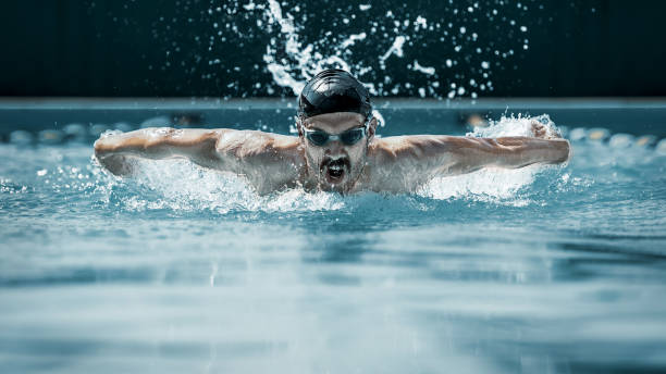 istock dynamic and fit swimmer in cap breathing performing the butterfly stroke 1032039280