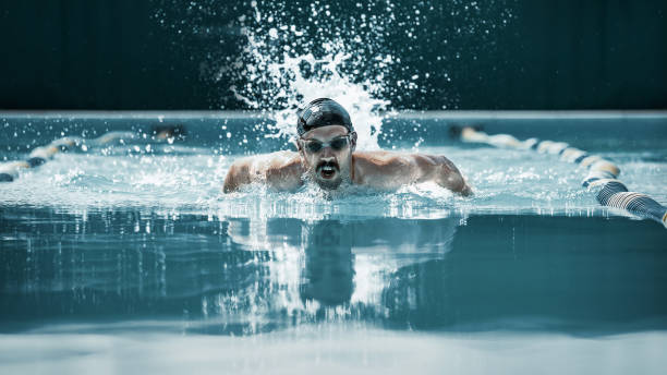 istock dynamic and fit swimmer in cap breathing performing the butterfly stroke 1032039352