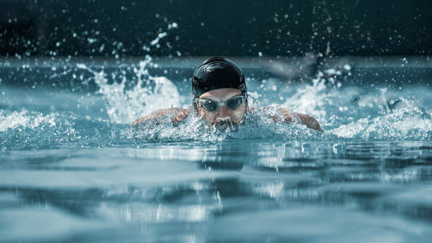 istock dynamic and fit swimmer in cap breathing performing the butterfly stroke 1032039362