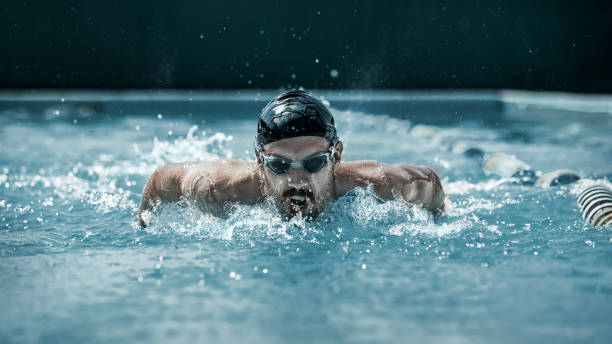 istock dynamic and fit swimmer in cap breathing performing the butterfly stroke 1032039370