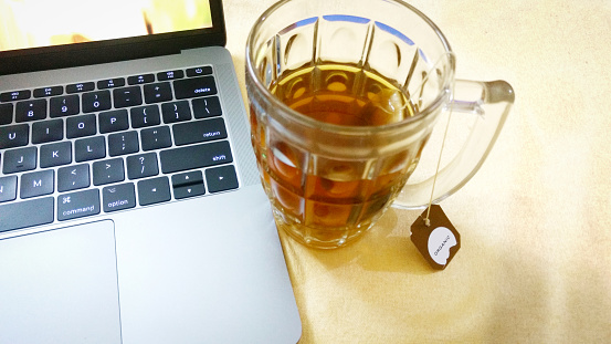 Organic Green Tea in Glass Mug Honey & Tulsi with MacBook Pro Laptop on side