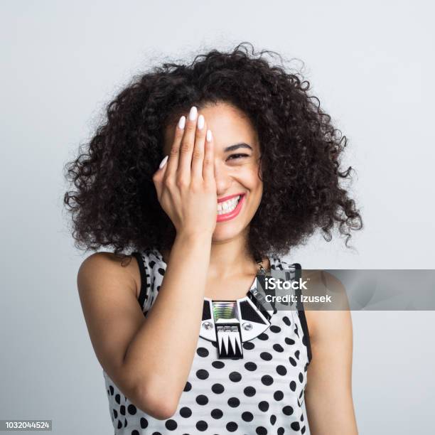 Cheerful Woman Covering Her One Eye Stock Photo - Download Image Now - Hands Covering Eyes, One Woman Only, Women