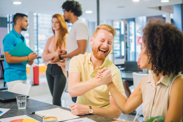 istock Young man shaking hands with female coworker and smiling 1032047830