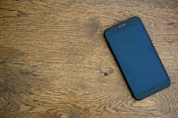 istock Mobile Phone On Wooden Texture 1032057350
