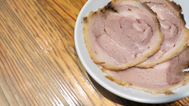 istock Chashu pork 3 pieces slice on the white color dish and wood table which additional menu for topping on tonkotsu ramen famous traditional food in Sapporo Hokkaido Japan. 1032057668