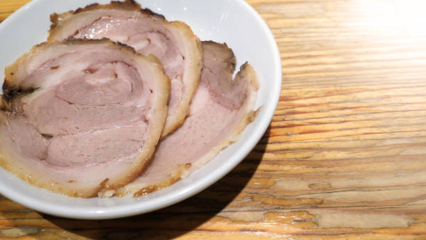istock Chashu pork 3 pieces slice on the white color dish and wood table which additional menu for topping on tonkotsu ramen famous traditional food in Sapporo Hokkaido Japan. 1032057670