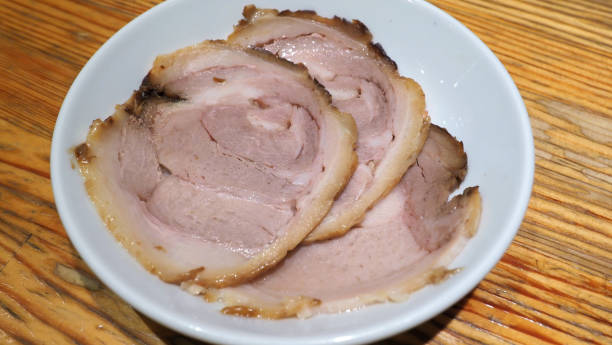 istock Chashu pork 3 pieces slice on the white color dish and wood table which additional menu for topping on tonkotsu ramen famous traditional food in Sapporo Hokkaido Japan. 1032057704