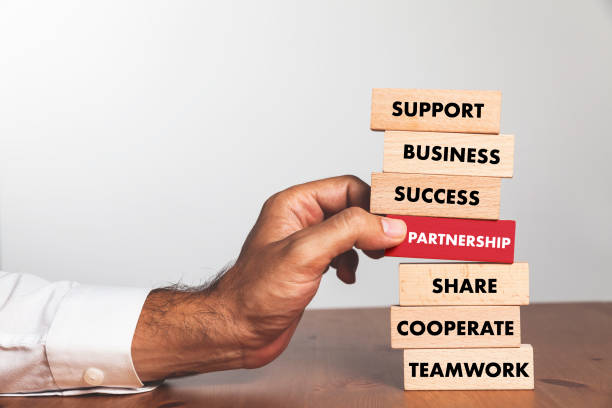 istock Businessman Building PARTNERSHIP concept with Wooden Blocks 1032059868