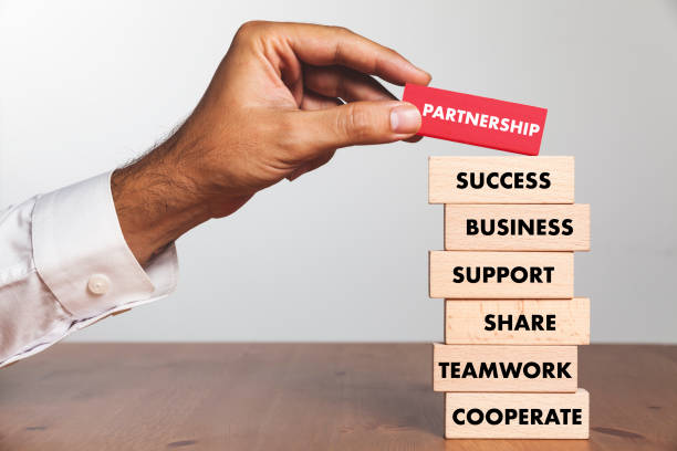 istock Businessman Building PARTNERSHIP concept with Wooden Blocks 1032059874