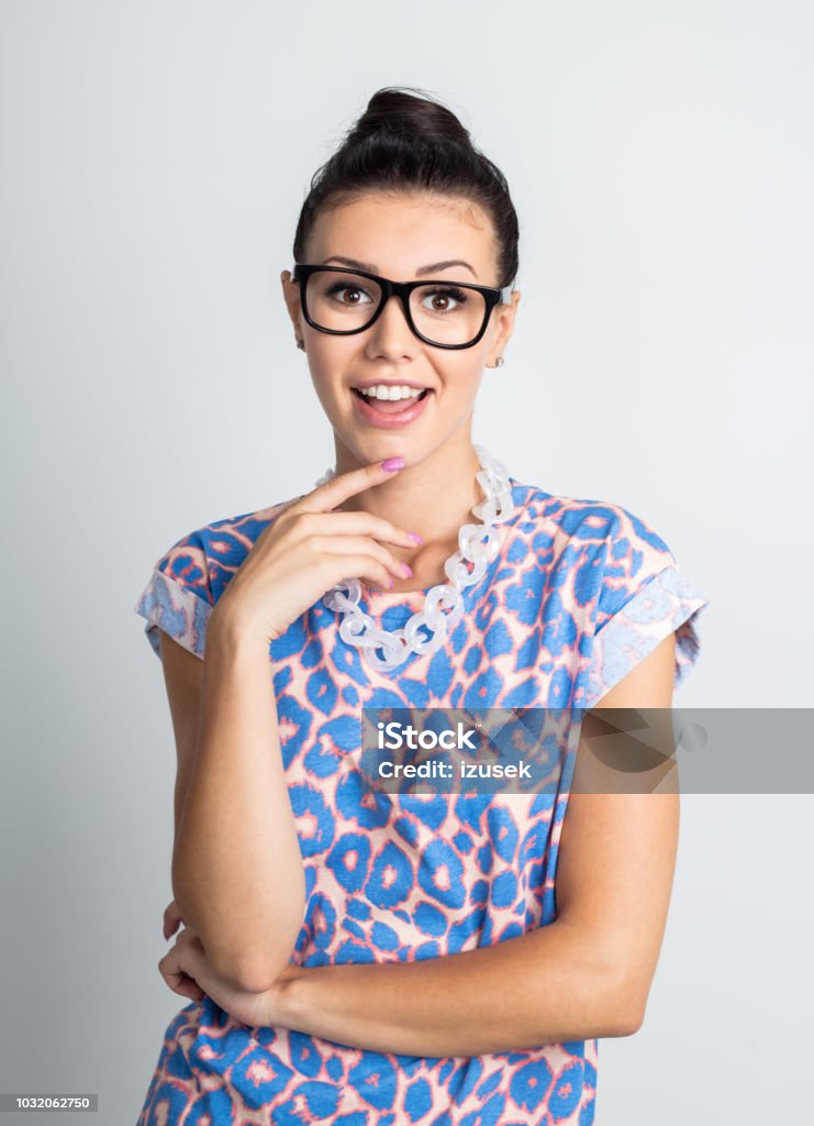 Pretty young woman looking surprised Portrait of young woman looking surprised on white background. Caucasian female model in casuals wearing eyeglasses staring at camera with surprised expression. 20-24 Years Stock Photo