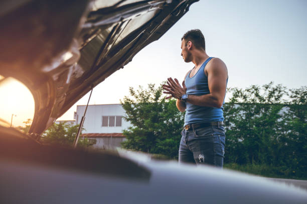 istock Worried man standing next to a broken down car 1032064952