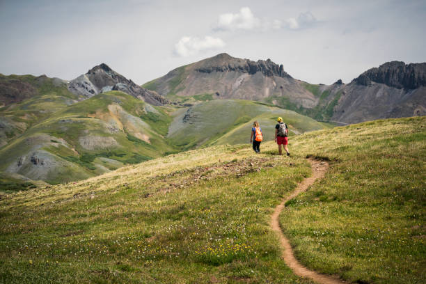 A teenage girl hikes with a woman through the mountains on the Continental Divide Trail, San Juan National Forest, Weminuche Wilderness, Rocky Mountains, Silverton, CO, USA