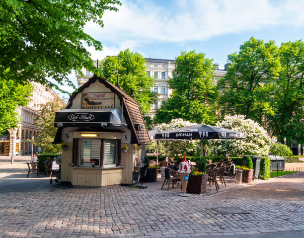 A 'Kioski' - a small traditionally Finnish style cafe in Esplanadi (Esplanade Park), central Helsinki, on a sunny morning in June. A few people are on their way to work and the kiosk cafe is about to open for business.
