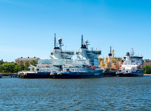 A group of ships belonging to Finland’s icebreaker fleet moored in Helsinki harbour on a sunny summer day. They are the Polaris (built in 2016), the Kontio (1987) and the Otso (1986); behind them is the Sisu (1976).
