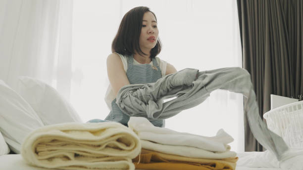 istock Woman folding laundry on the bed 1032087880