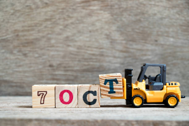 istock Toy forklift hold block T to complete word 7 oct on wood background (Concept for calendar date in month October) 1032088484