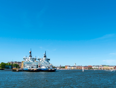 A group of ships belonging to Finland’s icebreaker fleet moored in Helsinki harbour on a sunny summer day. They are the Polaris (built in 2016), the Kontio (1987) and the Otso (1986); behind them is the Sisu (1976). Part of Helsinki’s lovely waterfront can be seen to the right, with its iconic Lutheran Cathedral standing on a hill.