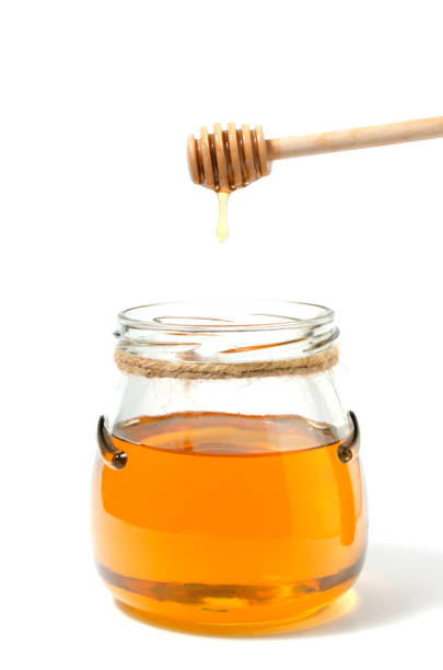 Natural fresh honey and honey spoon on white background.Close up.