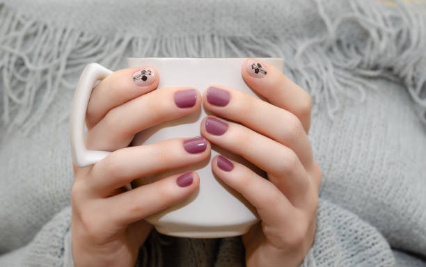 istock Female hands with dark pink nail design. 1032111180