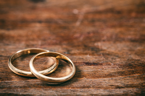 Dos anillos de boda dorados sobre fondo de madera, espacio de copia photo