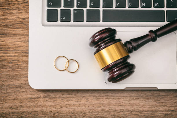 Wedding rings and judge gavel on computer laptop, wooden background, top view Divorce concept. Wedding rings and judge gavel on computer laptop, wooden background, top view gavel keyboard stock pictures, royalty-free photos & images