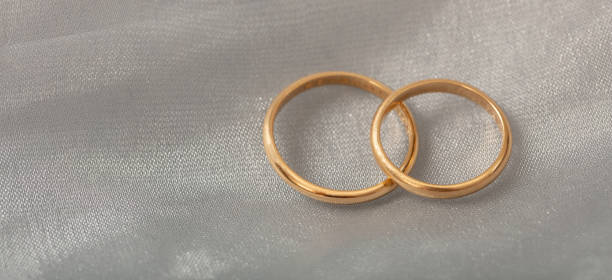 istock Two golden wedding rings on white silver background, copy space 1032112178