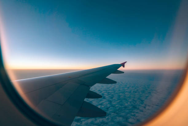 istock Airplane wing with sunrise in light flare 1032112416