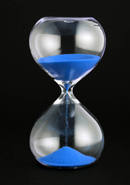istock Close-Up Of Hour Glass Against Black Background 1032116864