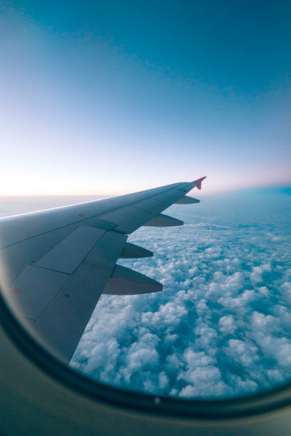 istock Airplane wing with sunrise in light flare 1032117026