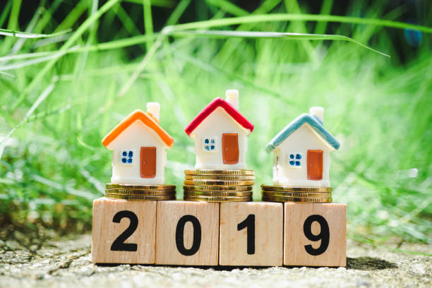 istock Miniature colorful house on golden stack coins 1032117888