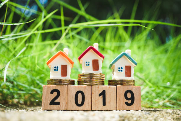 istock Miniature colorful house on golden stack coins 1032117912