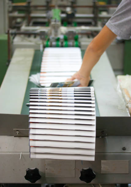 istock Cropped Hand Holding Papers In Printing Press 1032138582