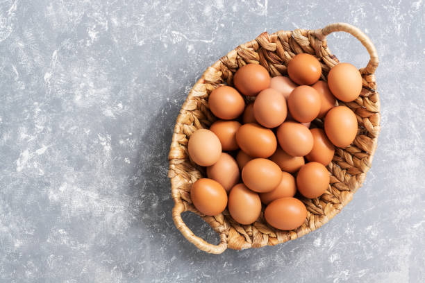 istock Fresh brown eggs in a basket on a gray background. View from above, flat lay.Copy space 1032150886