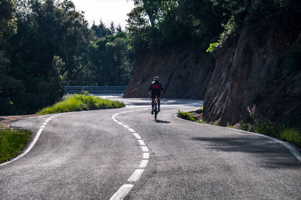 istock A cyclist drives on a very winding mountain road, surrounded by forest 1032164050