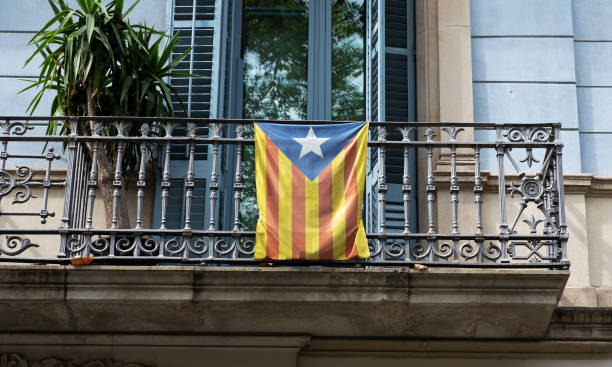 an estelada, the Catalan independentist flag, hanging on the railing of a balcony