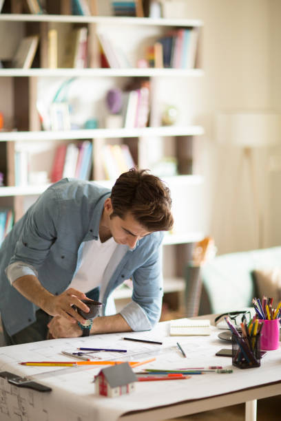istock Architect working with blueprints in the home office. 1032174278