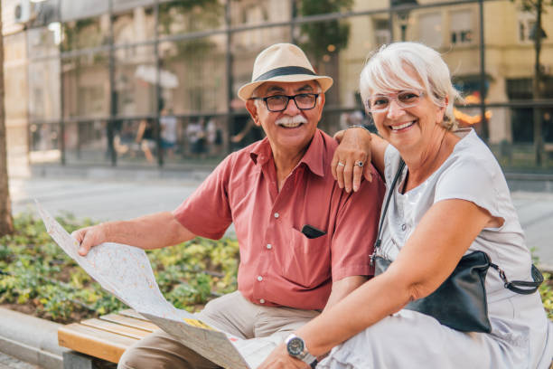 istock Happy old couple holding touristic map 1032178388