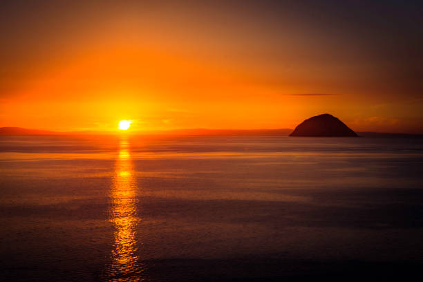 blick auf ailsa craig insel mit schönen atemberaubenden orangefarbenen abendsonne - ayrshire stock-fotos und bilder