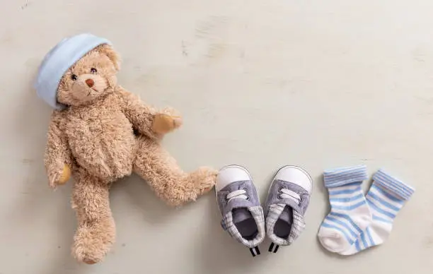 Photo of Baby boy shoes and socks on wooden background