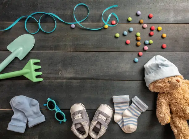 Photo of Baby boy shoes and socks on blue wooden background