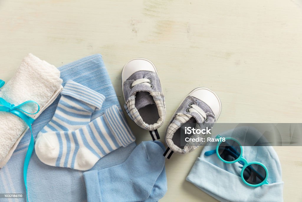 Baby boy clothes and accessories on wooden background Baby boy shower concept on wooden background, copy space, top view Childbirth Stock Photo