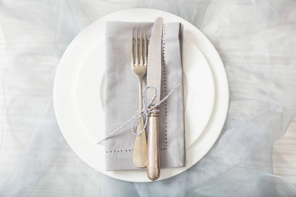 istock Holiday table place setting with plates, fork and knife, top view 1032189418