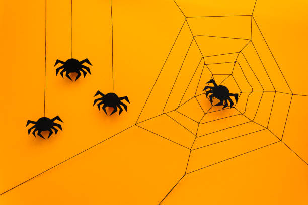 istock Black paper spider with web on yellow background. Halloween concept. Paper cut style. Top view 1032190878