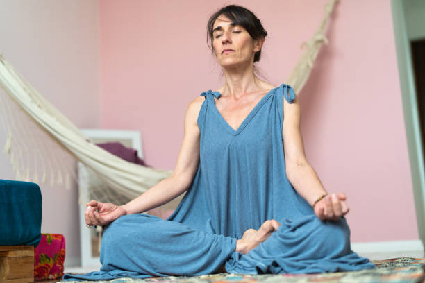 istock Mature Woman Practicing Yoga At Home 1032191012