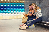 Girlfriends with mobile phone waiting for in the subway station