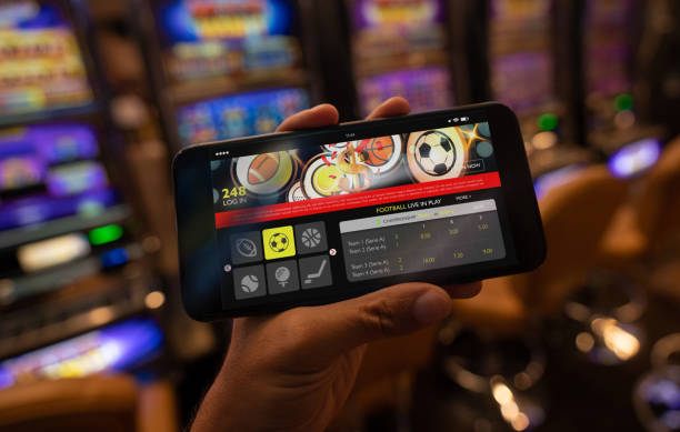 Unrecognizable person holding a smartphone with a sports betting application on screen Unrecognizable person at a casino holding a smartphone with a sports betting application on screen - Close up. **DESIGN ON SCREEN WAS MADE FROM SCRATCH BY US** sports betting stock pictures, royalty-free photos & images