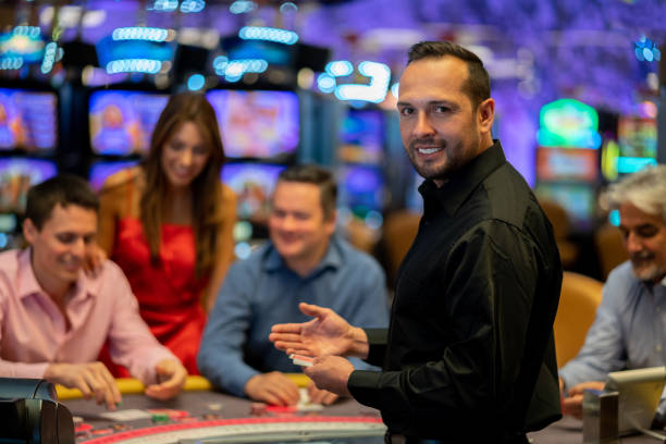 ritratto di rivenditore di carte al casinò guardando la fotocamera sorridente molto felice - croupier foto e immagini stock